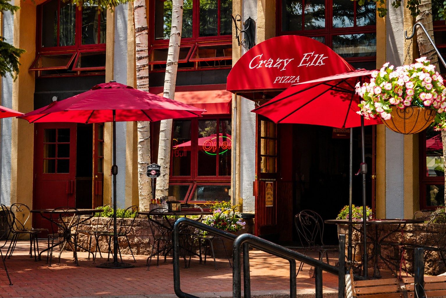Crazy Elk Pizza red awning, umbrellas, and patio entrance in Mountain Village